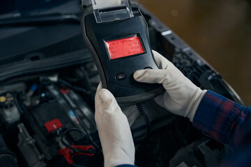 Close up photo of man holding voltmeter