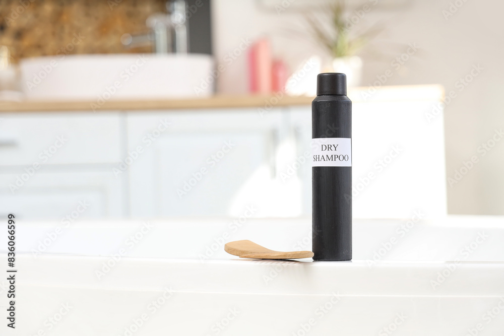 Dry shampoo with comb on bathtub in room, closeup