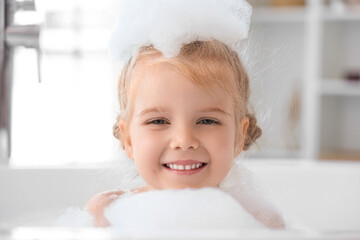 Wall Mural - Cute little girl with foam taking bath in bathroom
