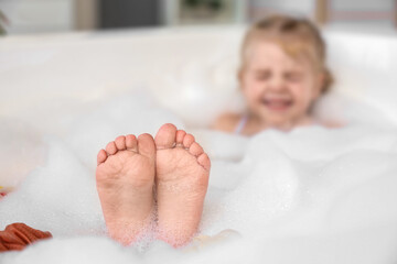 Wall Mural - Cute little girl taking bath in bathroom, closeup