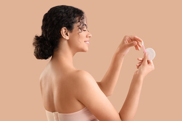 Poster - Young African-American woman with cotton pad and buds on beige background