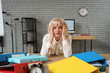 © Pixel-Shot - Stressed mature businesswoman sitting at desk in office