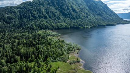 Wall Mural - beautiful landscape with mountains and Lake Teletskoye against a background of blue sky from a drone in May