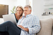 © Jadon Bester/peopleimages.com - Couple, couch and laptop in home and read, news and email in living room for social media. Internet, computer and relax for website or streaming with married people, calm and lounge with technology