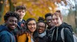 © trustmastertx - A group of young people in autumn, with trees with orange leaves in the background