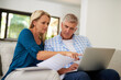 © Jadon Bester/peopleimages.com - Couple, couch and document with laptop and point, finances or taxes for audit in living room. Paperwork, contract or online for mortgage insurance, investment or man with female person in home lounge