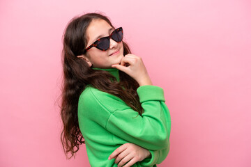 Canvas Print - Little caucasian girl wearing sunglasses isolated on pink background looking side