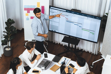 Wall Mural - Project manager communicate and collaborate with team using project management software display on monitor, tracking progress of project task and making schedule plan at meeting table. Prudent