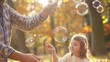 © Muhammad Riaz - A father's hands deftly maneuvering a bubble wand, while his daughter watches in awe, the soft focus highlighting the tenderness of their shared moment in the park