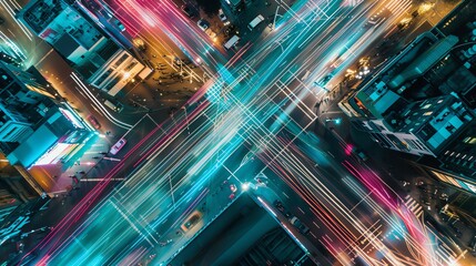 Wall Mural - Aerial view of a city intersection at night, with light trails from cars and traffic.