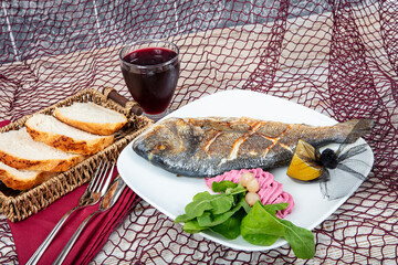 Wall Mural - Grilled sea bream, orata, dorado fish served on a plate with roasted. Grilled Dorada fish, sea bream with the addition of spices, herbs and lemon on the grill plate. Fried fish with vegetables.