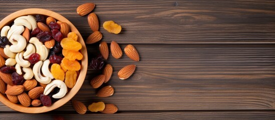 Poster - Variety of nuts, apricots, and raisins in a wooden bowl on a beige ceramic surface. Ample copy space for additional elements in the image.