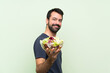 © luismolinero - Young handsome man with salad over isolated green wall
