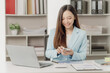 © MrAshi - Businesswoman working on financial documents on the desk in the office is writing notes and calculating income and expenses.