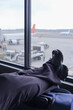 © Brand - Traveler Resting on luggage by Airport Window