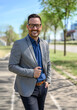 © Moon Safari - Portrait of confident male entrepreneur in eyeglasses posing happily on street in modern city