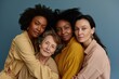 © netrun78 - Four multiethnic women with diverse skin tones and of different ages, standing closely, showcasing generational diversity and unity against a blue background..