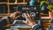 © Erin - a businessman's is using a laptop and touching virtual icons of sales performance, for a marketing plan or business growth, text 'GOAL'