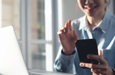 Poster - Young asian woman smiling and waving hand using smartphone app enjoying online virtual chat video call with friends on mobile chat virtual meeting, online working from home