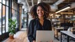 © EmmaStock - Smiling female entrepreneur with laptop standing in office