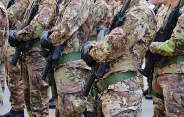 platoon of soldiers with green and brown camouflage uniform with black gloves and assault rifle in hand