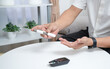 © Attasit - An elderly man uses a blood pressure monitor to measure his health at home.