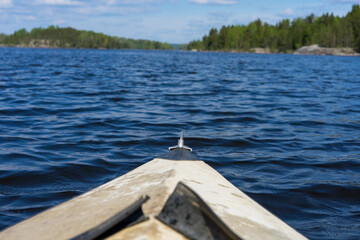 Wall Mural - The front of a kayak floating on a lake against a backdrop of beautiful nature