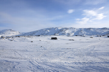 Wall Mural - Scenic daytime snowy landscape with mountains in the background