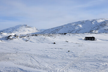 Wall Mural - Scenic daytime snowy landscape with mountains in the background