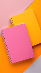 Wall Mural - Top view of two spiral notebooks on pink and orange table background.