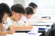 © kapinon - 小学校や塾の教室で勉強する小学生の子供たち　テストや試験を受ける