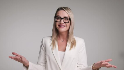 Wall Mural - excited businesswoman in white suit celebrating while clapping hands and pointing fingers forward