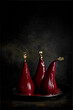© Sharon Cosgrove - Poached pears in red wine  sauce with gold leaf on a dark background