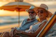 ©  J. GALIÑANES STOCK - Portrait of a middle-aged couple wearing sunglasses and straw hats enjoying the beach at sunset. Concept of middle age, healthy lifestyle, and outdoor activities.