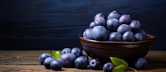 Poster - Autumnal blue plums compote displayed on a wooden tabletop with copy space image.