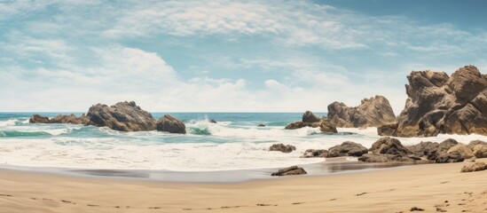 Aufkleber - Sandy beach with rocks and waves, suitable for a copy space image.