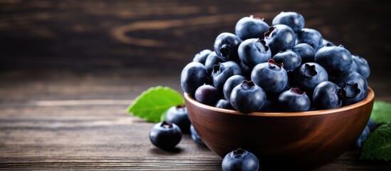 Poster - Close up image of fresh blueberries in a small bowl on a wooden table with copy space image.