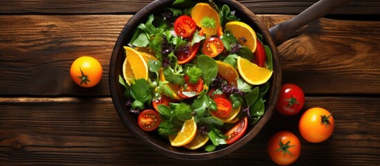 Poster - Vegetable salad with orange slices displayed on a rustic wooden background with a pan in the shot for a copy space image.