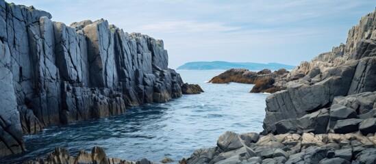 Poster - The rocks along the coastline create a scenic backdrop with copy space image.