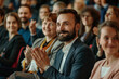 © Surachetsh - A side view of a diverse group of business people clapping and smiling at an event, showcasing camaraderie and success.