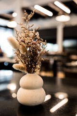 Wall Mural - Dried flowers or dried flowers in a white ceramic vase. Minimalist decoration on the table.