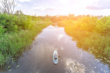 Wall Mural - Suzdal, Russia, Golden Ring: A tourist girl swims along the river past the sights of the ancient Russian city of Suzdal in the warm summer