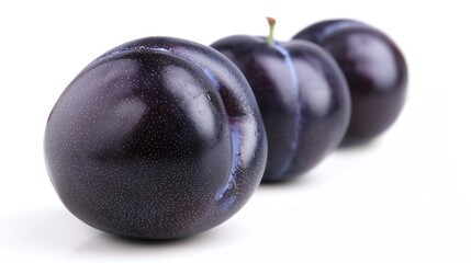 Closeup of a juicy plum with a deep purple skin and a slight sheen, isolated on a white background