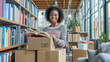 © mikhailberkut - Smiling Young Woman Unpacking Books in New Home Library