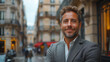 © ML - Handsome businessman in suite smiling and standing on the street in Europe