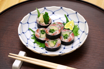 Wall Mural - A Japanese sushi restaurant roll dish of pickled sardines and ginger wrapped in nori seaweed.