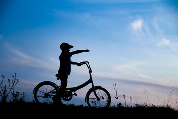 Canvas Print - A Happy child and bike concept in park outdoors silhouette