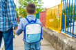 © Dragana Gordic - Boy with rucksack infront of a school building. Child with a backpack. First day at school. father leads a little child school boy in first grade.