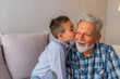 © Dragana Gordic - Beautiful little boy kissing happily his grandfather. Child kiss grandfather. Great grandfather taking care of grandchild while sitting on couch.