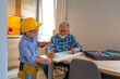 © Dragana Gordic - Loving Grandfather Spending Teaching Grandson Craft. Grandfather and his grandson having fun in the Indoor workshop. Little boy and grandson repairing in the kitchen